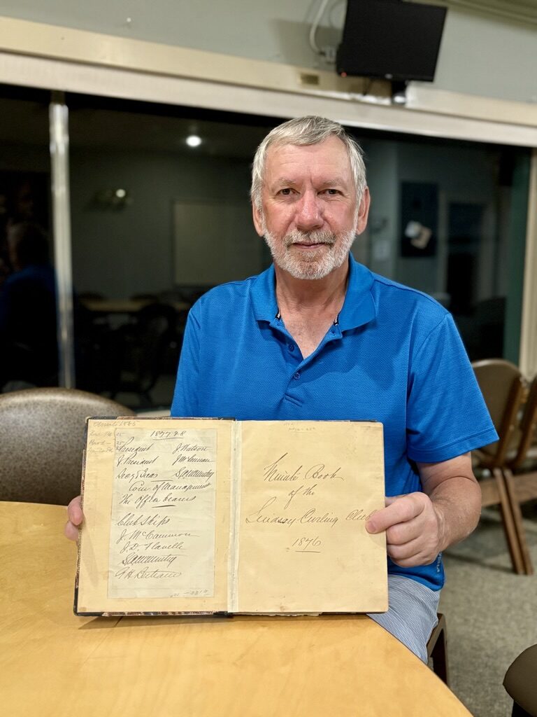 Dave Nigh, General Manager, holds the original Lindsay Curling Club Minute Book from 1876.